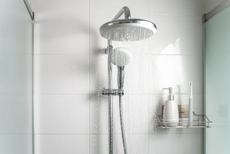 Shower head with water coming out of it - Peter Levi
