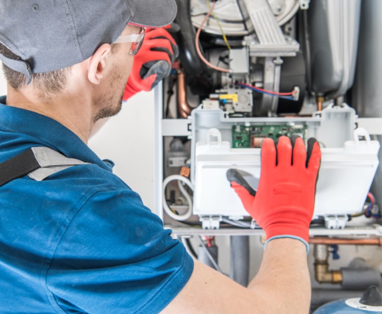 hvac technician completing maintenance on a furnace