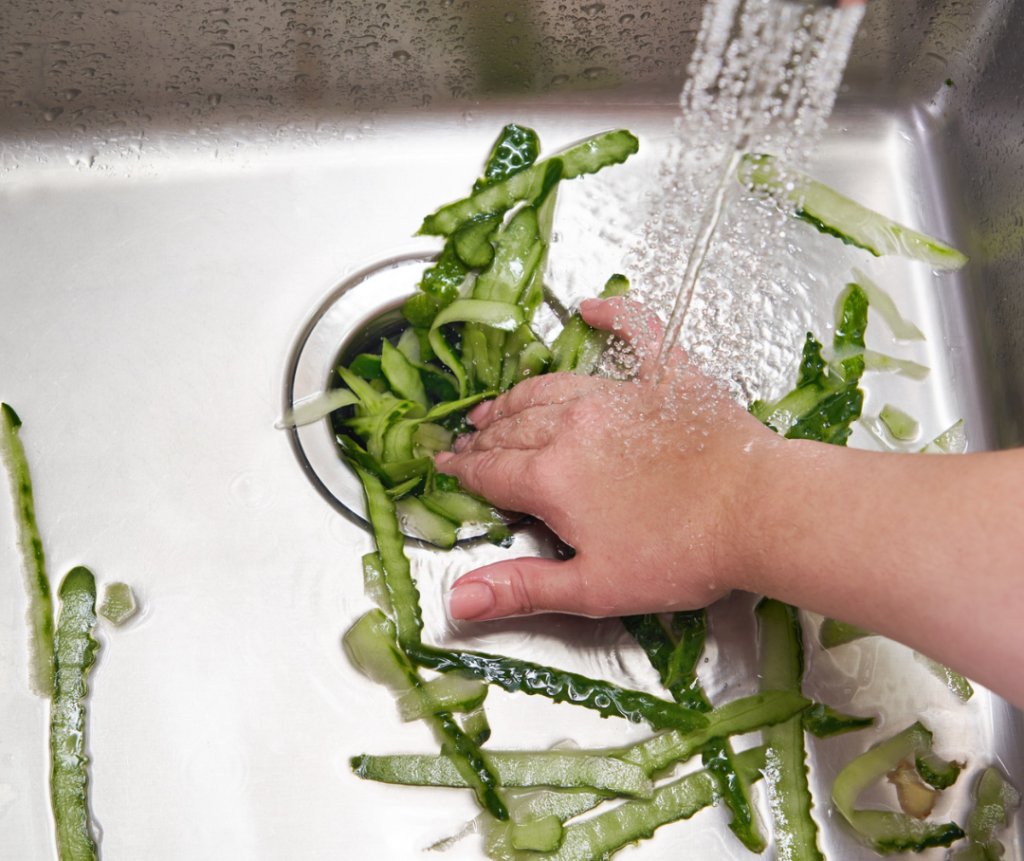 hands cleaning vegetables in a wink with running water