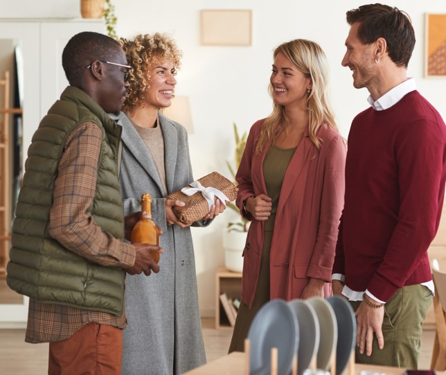 four people talking at a holidy event at a home